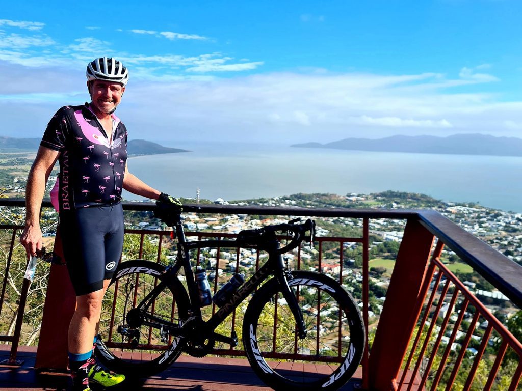 Patrick Sutton, Principal of Legalsense NQ standing with his bike at Castle Hill lookout