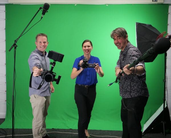 Bede Ashley holding a camera, Naomi Watts holding a camera and Michael Bromage with sound equipment in front of a green screen