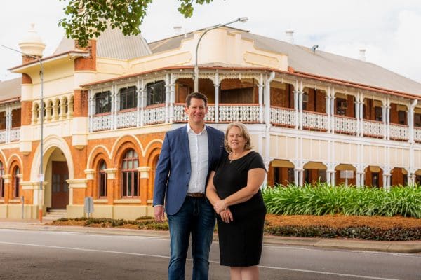 Matthew Smith and Therese Smith standing in front of the Queen's Hotel, The Strand
