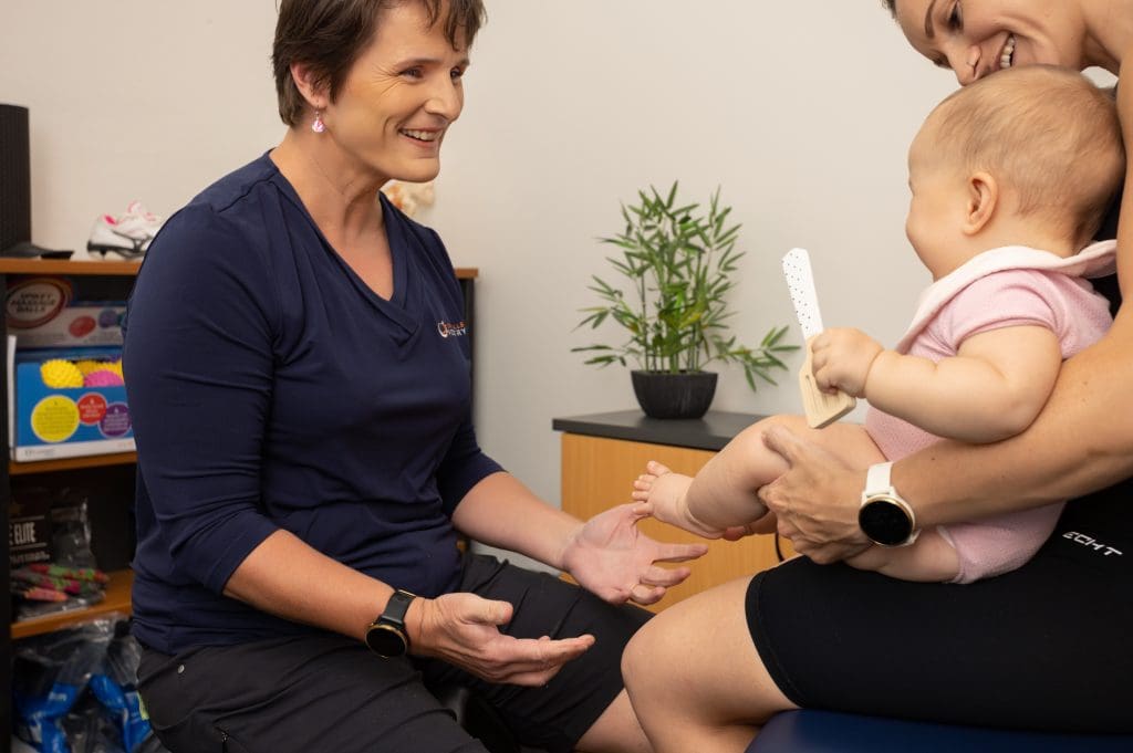 Daina Clark with infant patient and parent at Townsville Podiatry