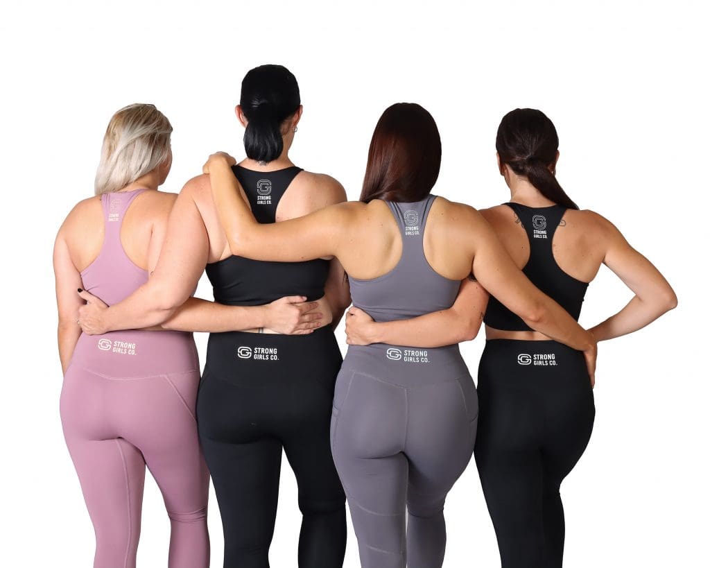 Four women with backs turned wearing clothing from Strong Girls Co.