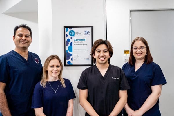 Group of people in dentists scrubs smiling at camera