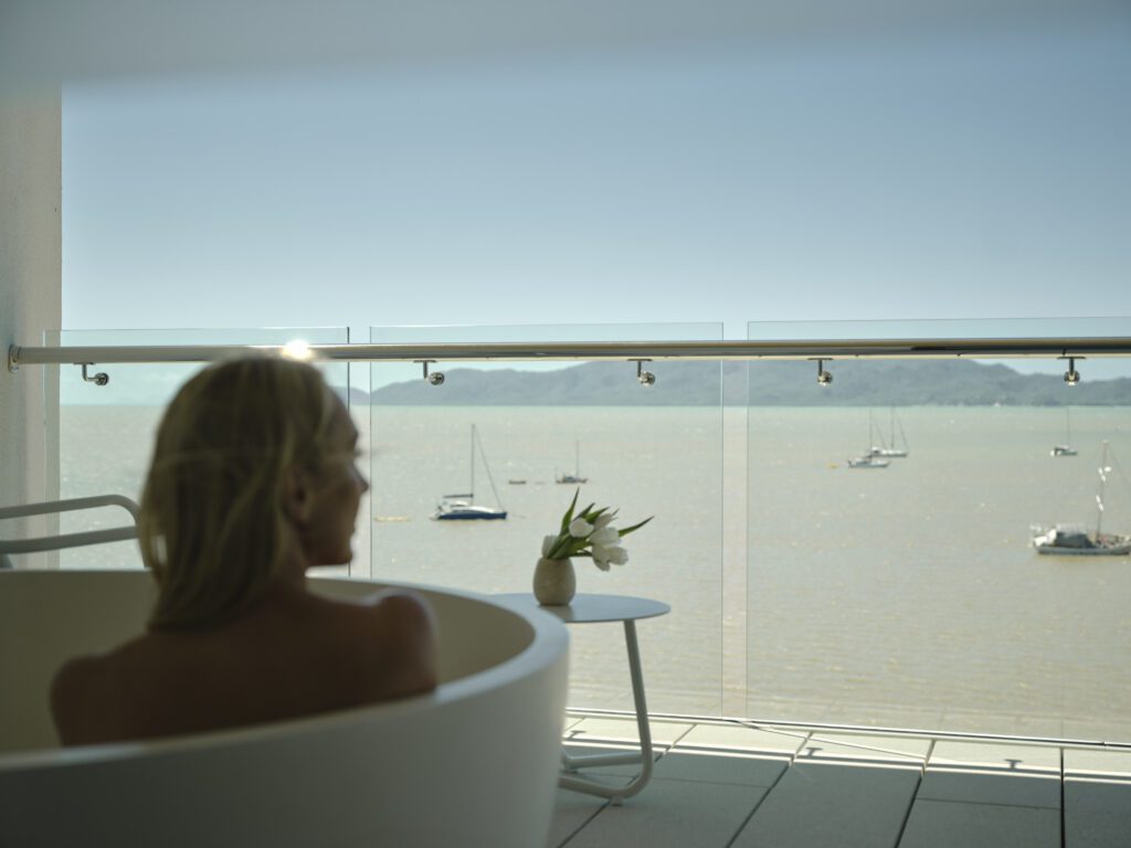 Woman in balcony bath in the Ardo Suite overlooking the Coral Sea at Ardo Townsville. Townsville’s first luxury hotel is now taking bookings | BDmag November 2023