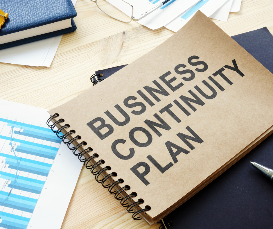 binder with "Business Continuity Plan" written on front on desk of business paper work. NQGRC Simon Hompas Can your business tolerate disruption this cyclone season? | BDmag Dec 2023