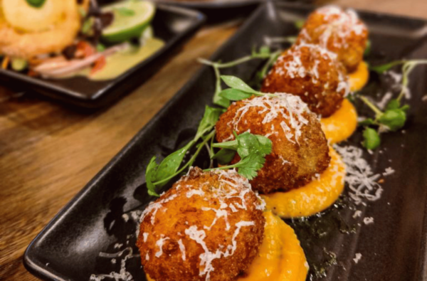 Arancini Balls lined on plate, made by The Spirited Goat. BDmag. February 2024.