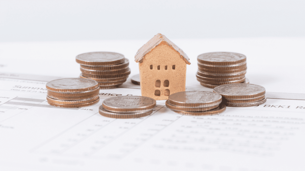 Stock image. cork house surrounded by stacked coins. BDmag Feb 2024.