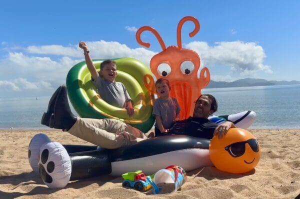 The Townsville Airport Father's Day at Picnic Bay event, as part of SeaLink Magnetic Island Race Week will bring about 1500 people to Magnetic Island. Townsville Airport General Manager Brendan Cook, with his sons on inflatables on the beach.